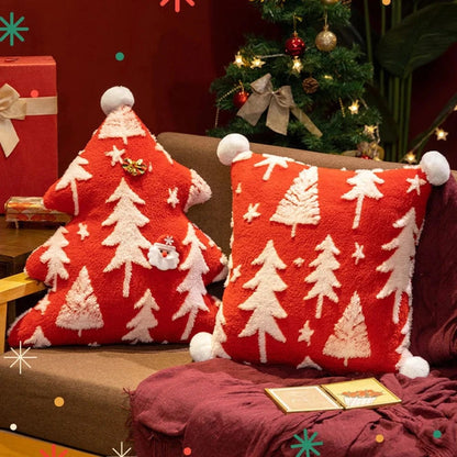 Coussins décoratifs rouges en forme d'arbre de Noël avec motifs de sapins blancs sur un canapé