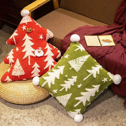 Coussins décoratifs en forme d'arbre, rouge et vert, avec motifs de sapins, sur un fauteuil en rotin