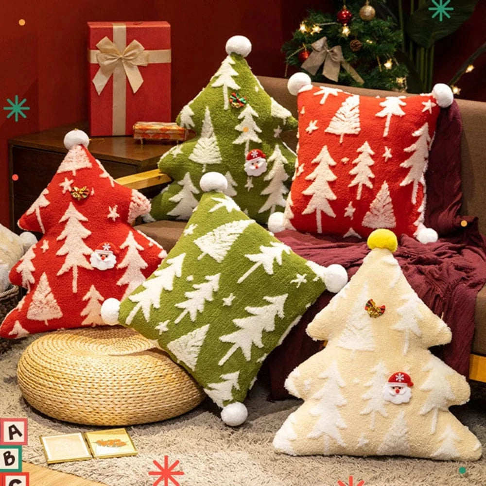 Coussins décoratifs en forme d'arbre de Noël, aux couleurs rouge, vert et crème, sur un canapé dans un salon chaleureux