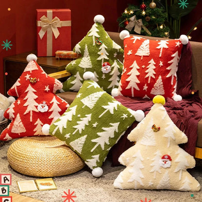 Coussins décoratifs en forme d'arbre de Noël, aux couleurs rouge, vert et crème, sur un canapé dans un salon chaleureux
