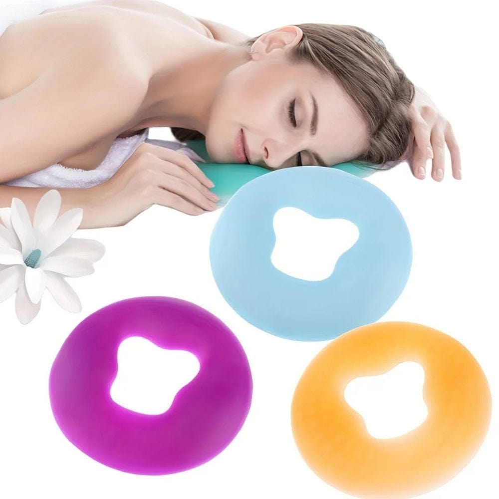 Trois coussins de massage colorés en silicone, violet, bleu et orange, posés sur une surface blanche