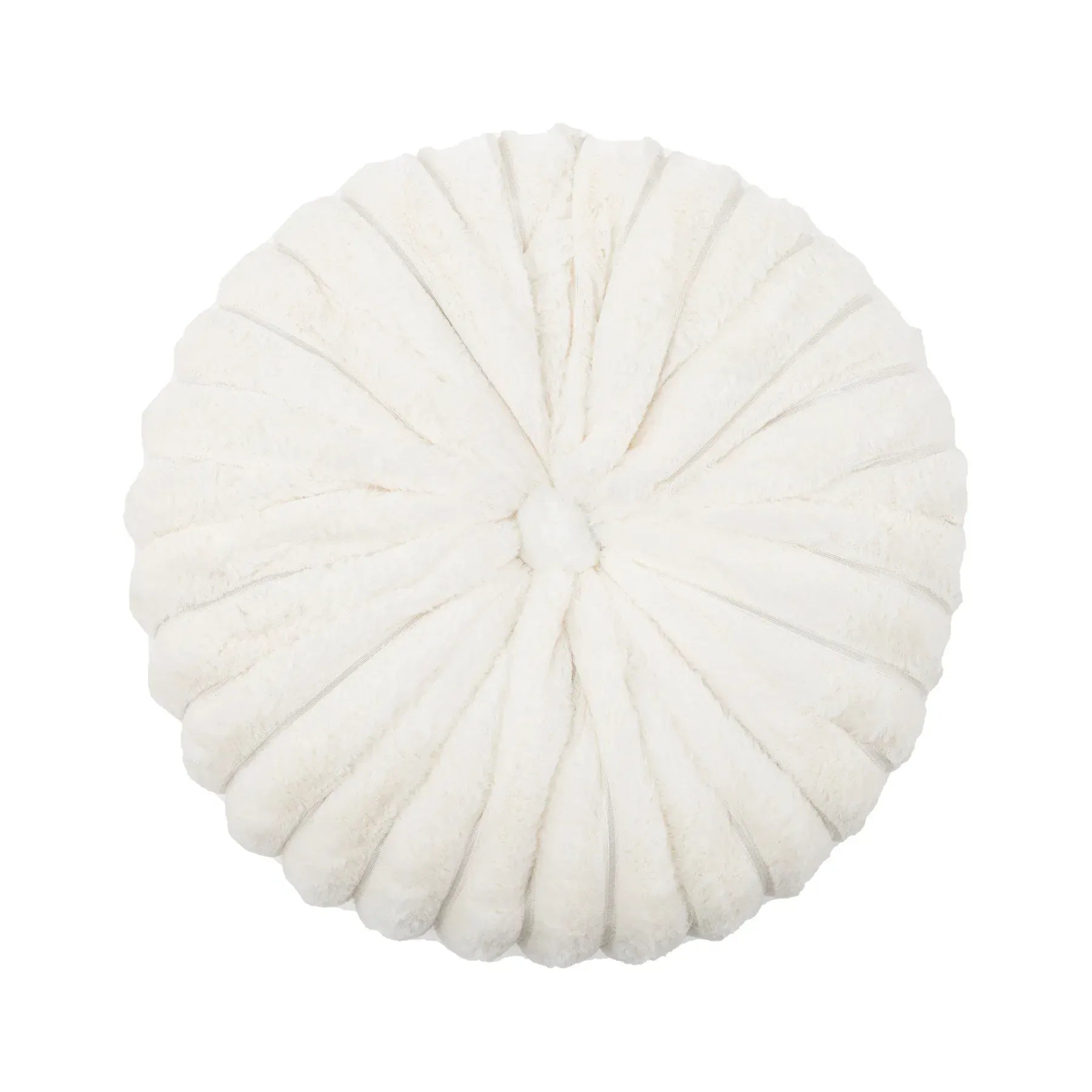 Coussin déco rond en velours blanc, avec des plis décoratifs, posé sur un canapé moderne