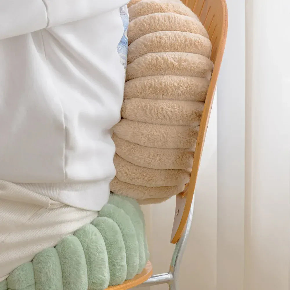 Coussin moelleux beige à rayures, posé sur une chaise en bois, apportant confort et style à votre décoration intérieure