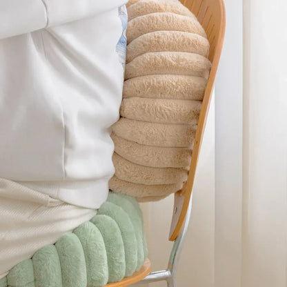 Coussin moelleux beige à rayures, posé sur une chaise en bois, apportant confort et style à votre décoration intérieure