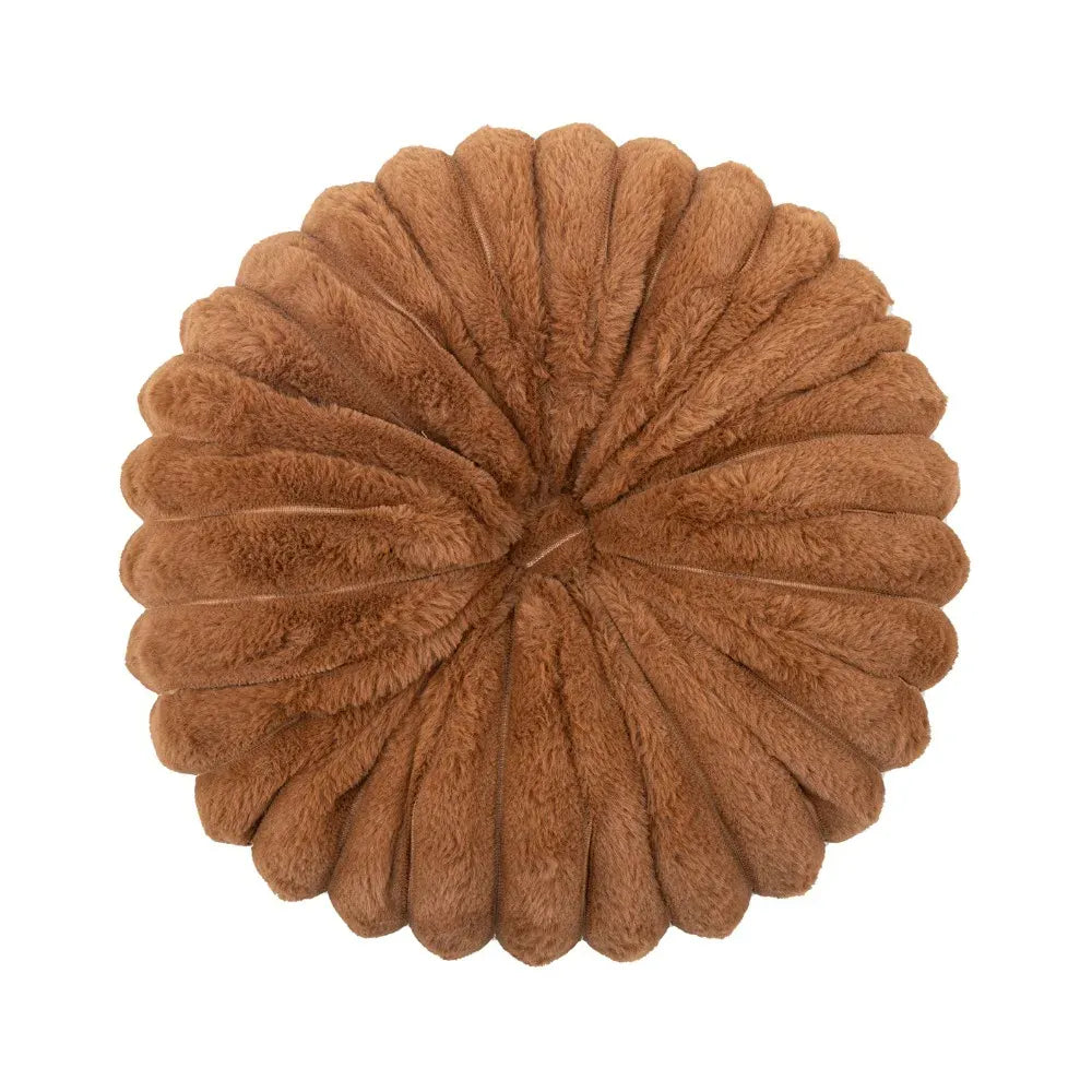 Coussin déco rond en velours marron, moelleux, posé sur un canapé, avec un motif en pétales