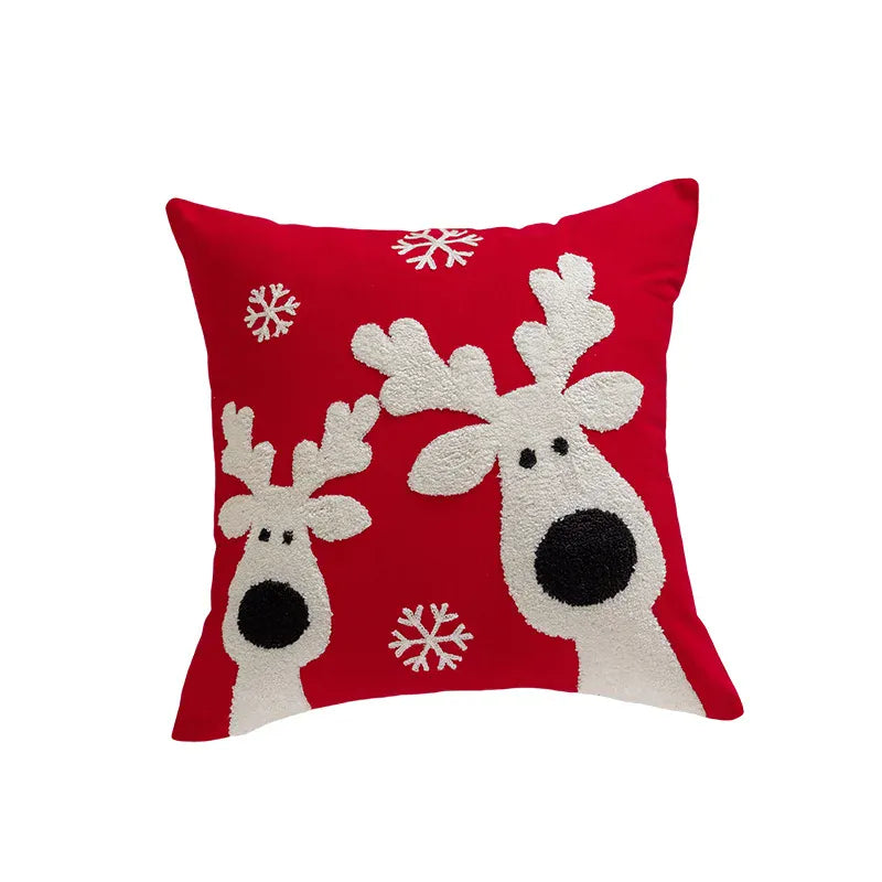 Coussin décoratif rouge avec motifs de rennes et flocons de neige, idéal pour un canapé festif