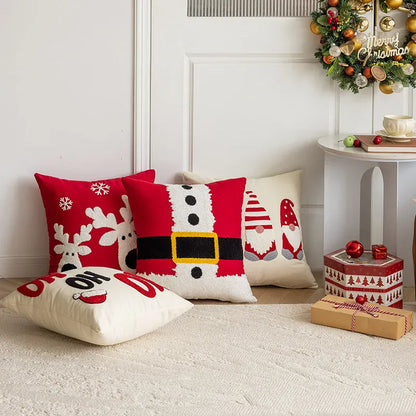 Coussins décoratifs aux motifs de Noël, rouges et blancs, posés sur un tapis dans un salon chaleureux