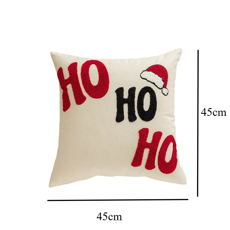 Coussin décoratif beige avec motifs "HO" en rouge et noir, idéal pour un canapé ou un lit pendant les fêtes