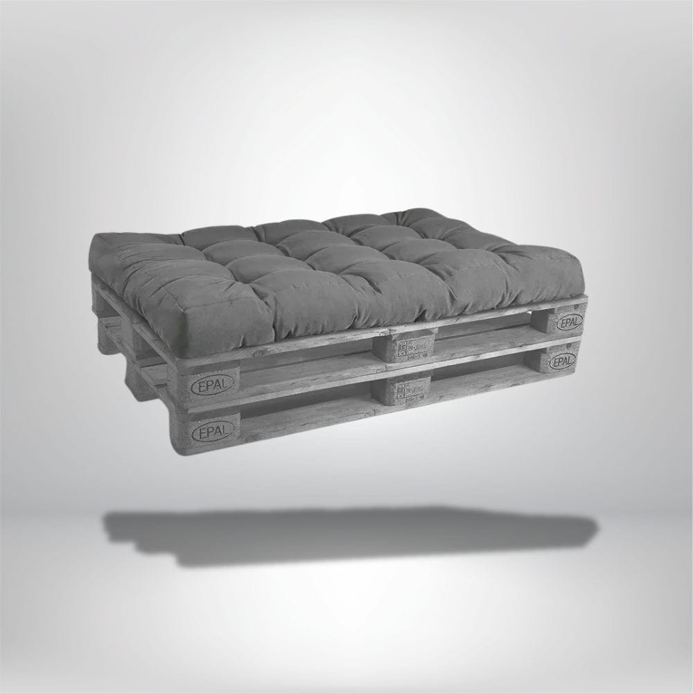 Coussin déco rectangulaire en velours gris posé sur une palette en bois, idéal pour un salon moderne