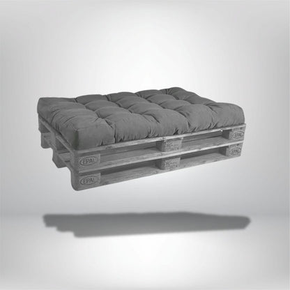 Coussin déco rectangulaire en velours gris posé sur une palette en bois, idéal pour un salon moderne