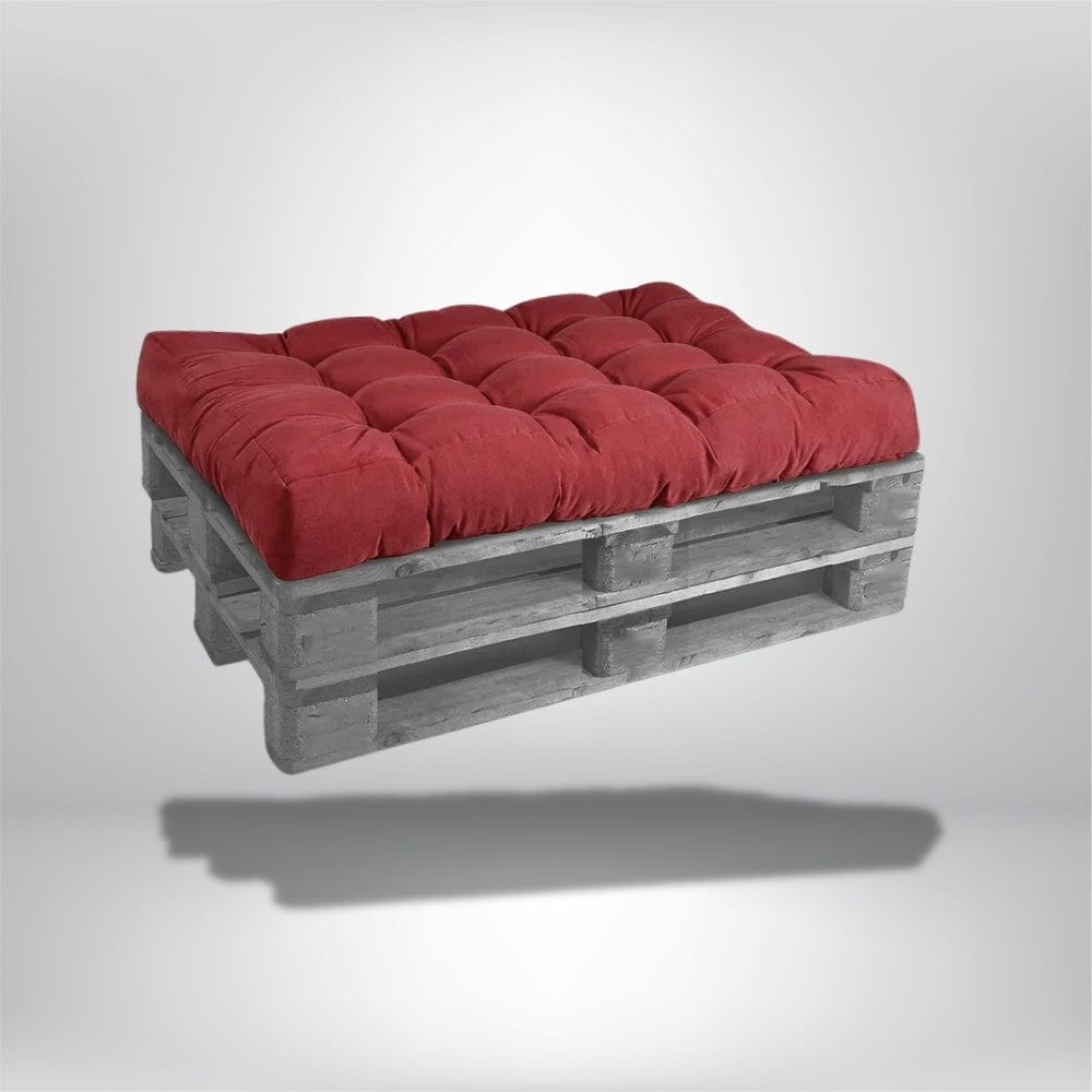 Coussin déco rectangulaire rouge en velours sur une palette en bois, idéal pour un salon moderne