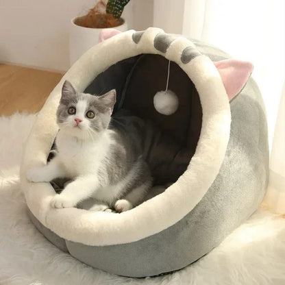 Coussin en forme de panier pour chat, gris et blanc, avec oreilles et intérieur doux, placé sur un tapis