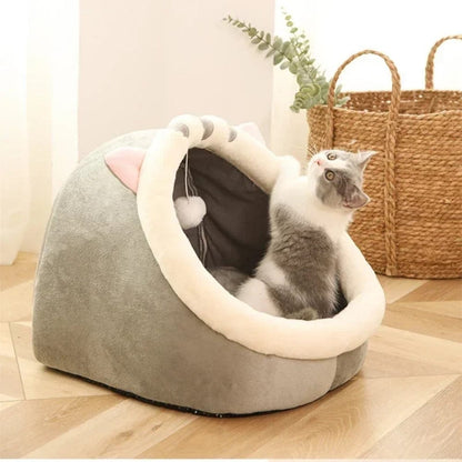 Coussin décoratif en forme de panier pour chat, en velours gris et blanc, placé sur un sol en bois