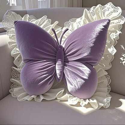 Coussin décoratif en velours violet en forme de papillon avec un bord en dentelle blanche sur un canapé