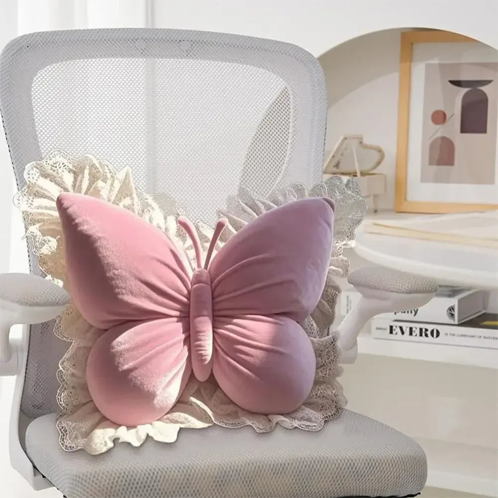 Coussin décoratif en forme de papillon rose sur une chaise blanche, avec des détails en dentelle