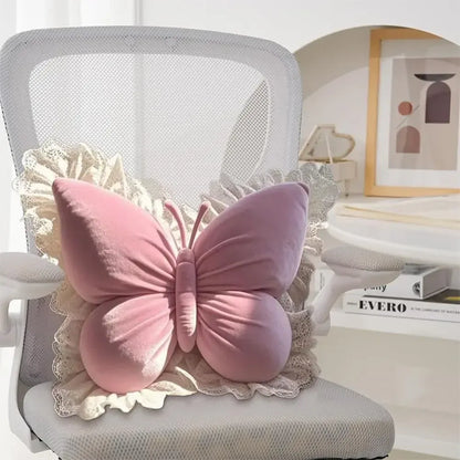 Coussin décoratif en forme de papillon rose sur une chaise blanche, avec des détails en dentelle