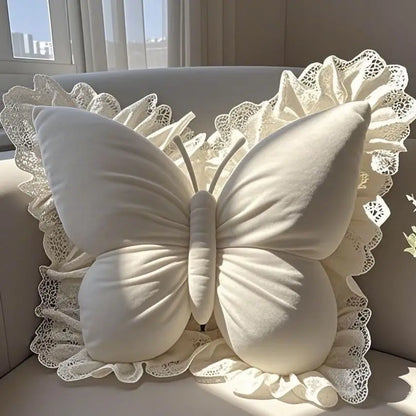 Coussin décoratif en forme de papillon blanc avec bordure en dentelle, posé sur un canapé lumineux