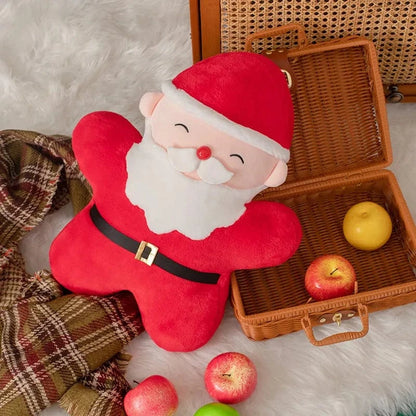 Coussin décoratif en forme de Père Noël, rouge et blanc, posé sur un plaid dans un salon chaleureux