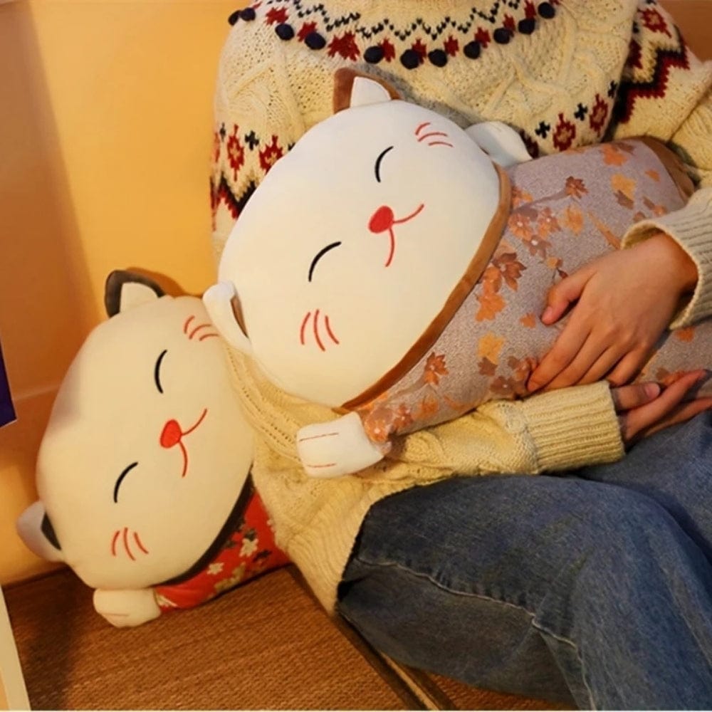 Coussins décoratifs en forme de chat, aux motifs floraux et couleurs douces, posés sur un canapé