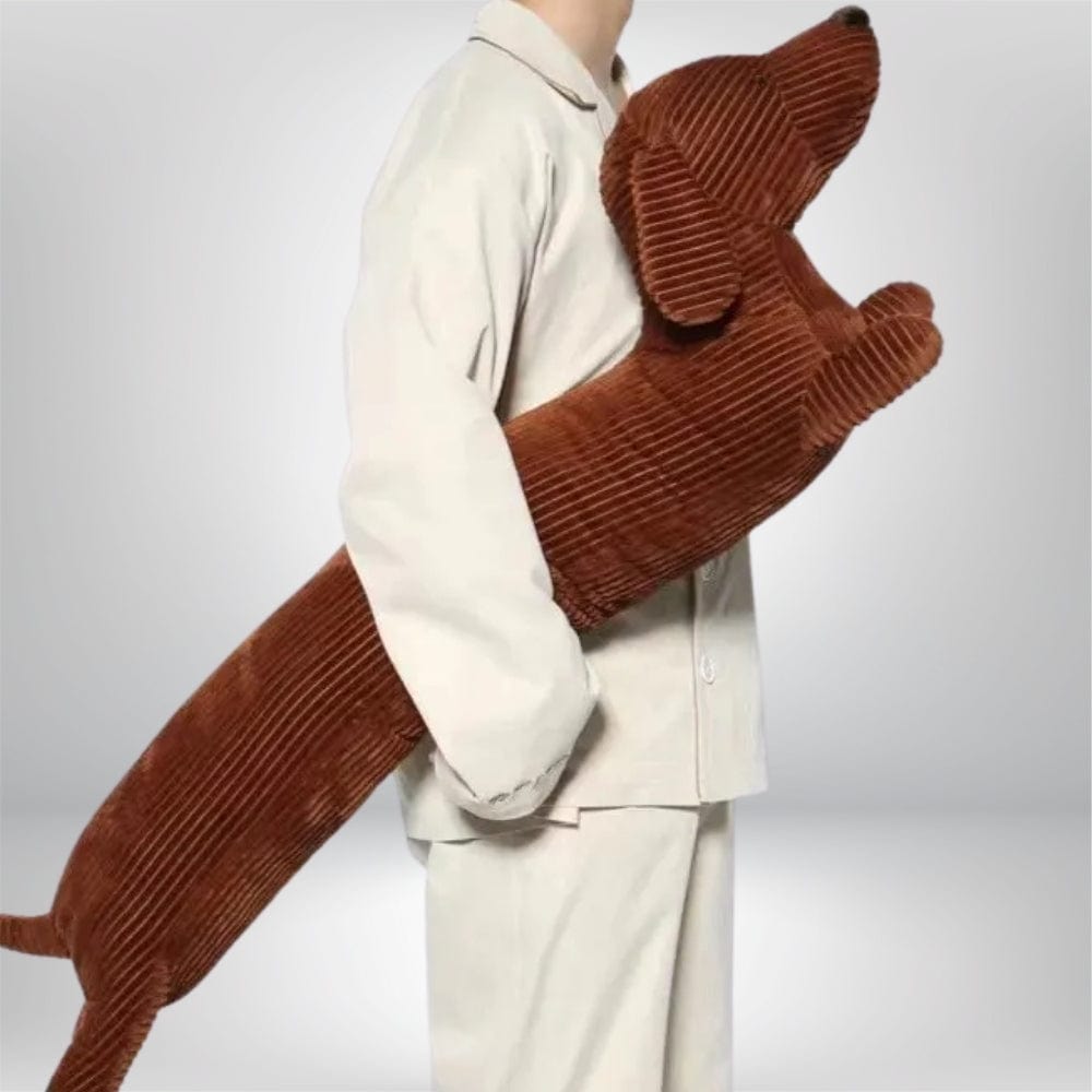 Coussin décoratif en forme de chien, couleur marron, en velours côtelé, porté par une personne en pyjama