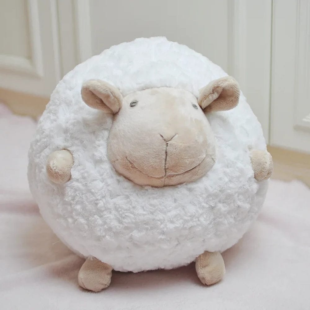 Coussin décoratif en forme de mouton, doux et moelleux, posé sur un tapis clair dans une chambre