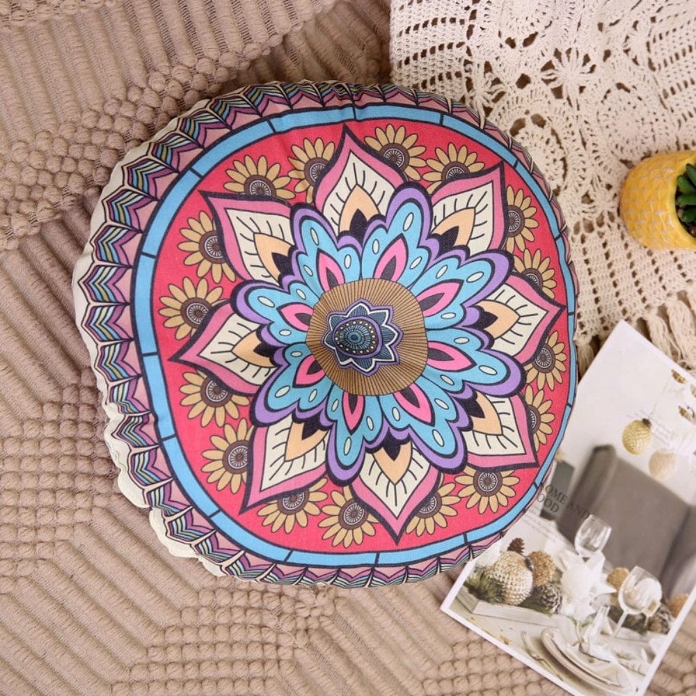 Coussin pouf de sol rond aux motifs floraux colorés, posé sur un tapis beige, ajoutant une touche décorative