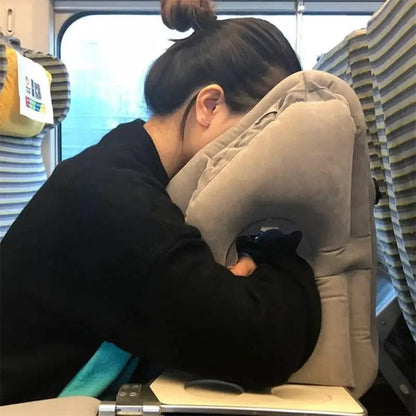 Coussin de voyage gris en velours, offrant un soutien confortable pour la tête dans un train