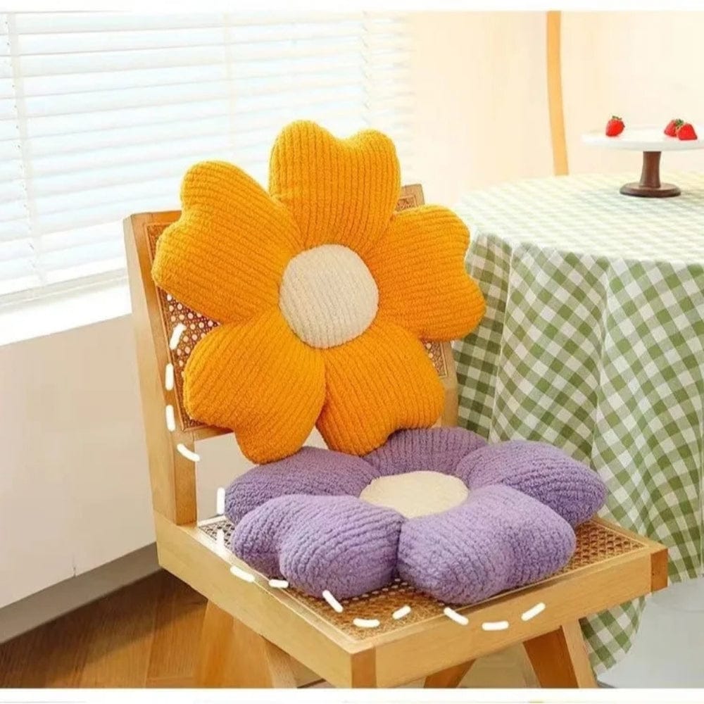 Coussins décoratifs en forme de fleurs, orange et violet, sur une chaise en bois dans un intérieur lumineux