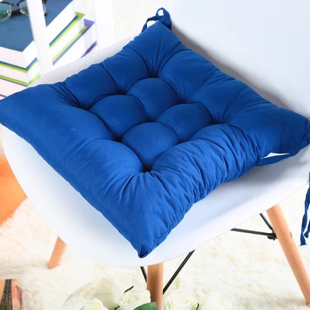 Coussin de chaise de jardin en tissu bleu, matelassé, posé sur une chaise blanche moderne dans un salon lumineux