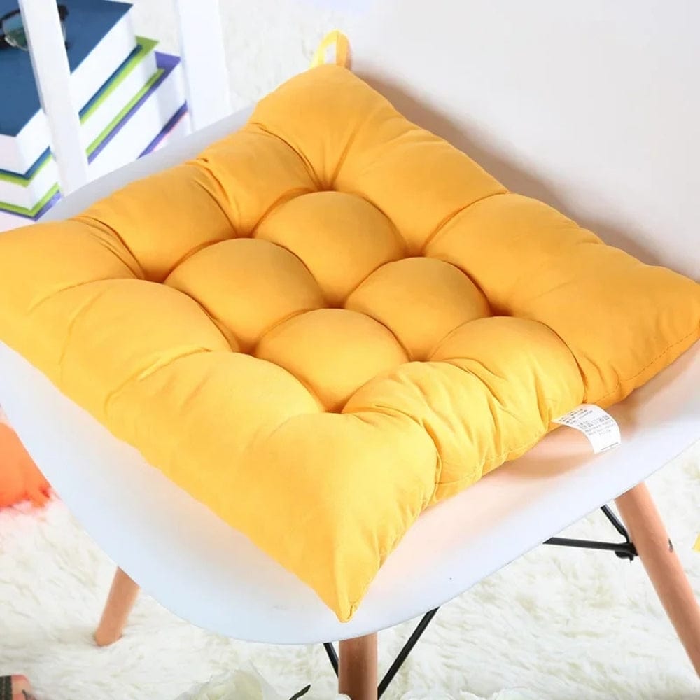 Coussin de chaise de jardin en tissu jaune avec un design matelassé et des formes arrondies, posé sur une chaise