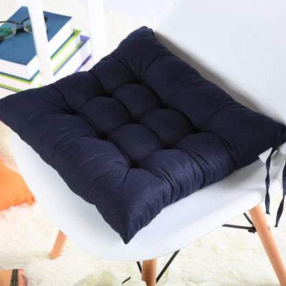 Coussin de chaise de jardin en tissu bleu marine, rembourré avec des coutures matelassées, posé sur une chaise blanche