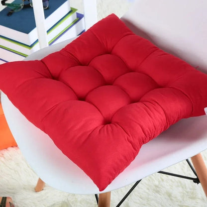 Coussin de chaise de jardin rouge, rembourré avec des motifs capitonnés, posé sur une chaise blanche moderne