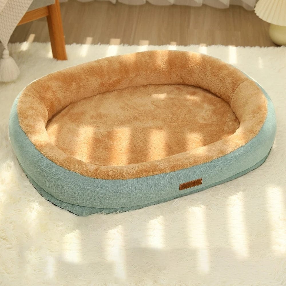 Coussin décoratif oval en tissu bleu avec intérieur doux beige, posé sur un tapis moelleux dans un salon