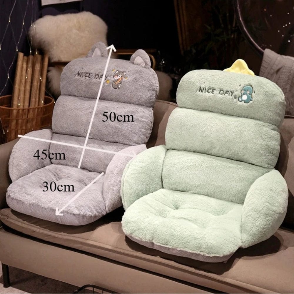 Coussins décoratifs en peluche grise et verte, avec des motifs d'animaux, posés sur un canapé confortable