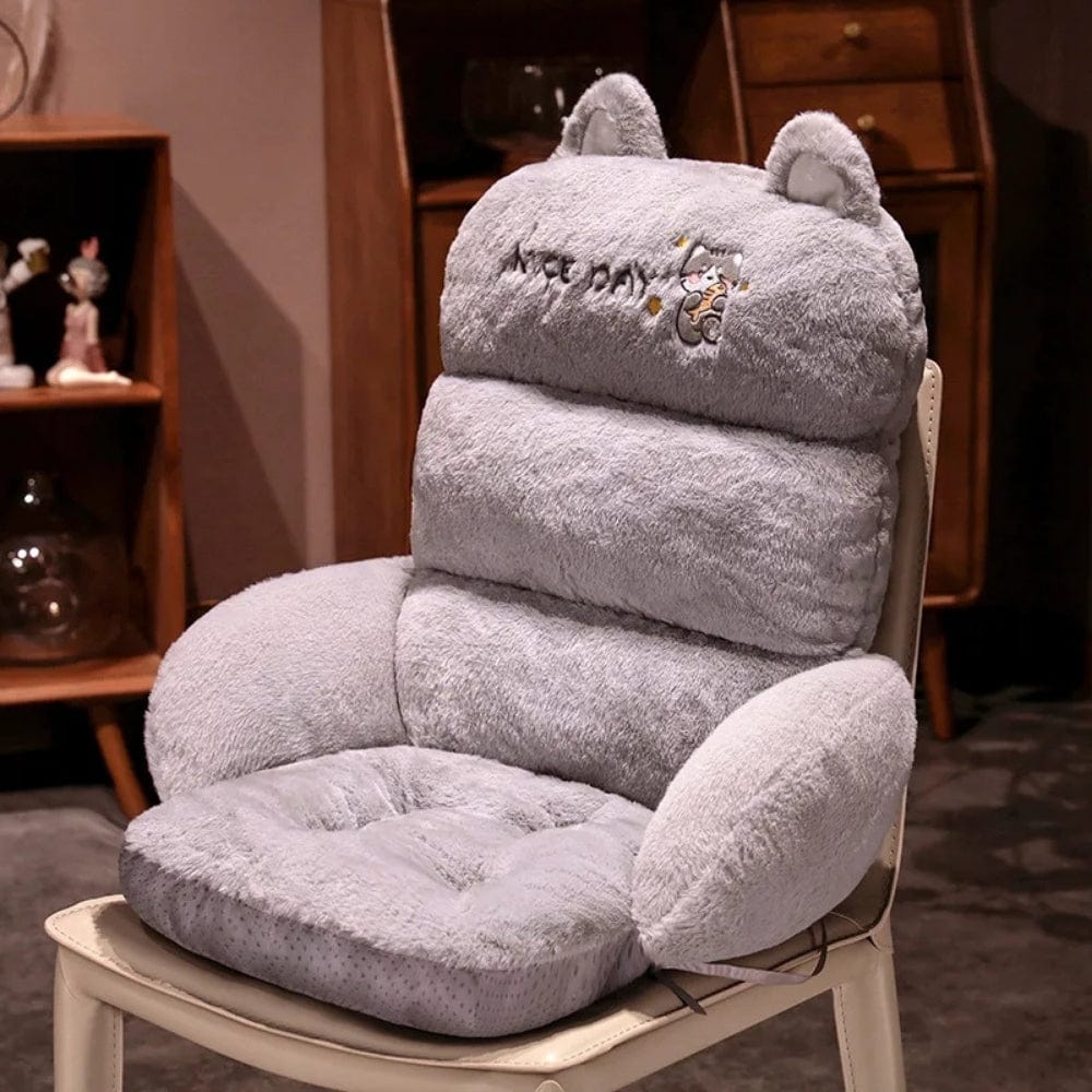 Coussin décoratif en velours gris, avec oreilles de chat, sur un fauteuil dans un salon moderne
