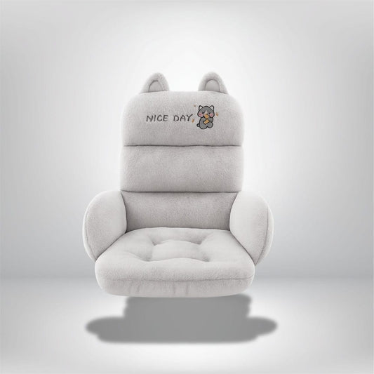 Coussin décoratif en peluche grise avec oreilles, posé sur un fauteuil confortable dans un salon moderne
