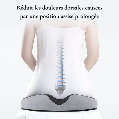 Coussin ergonomique gris sur une surface blanche, conçu pour un confort optimal en position assise prolongée