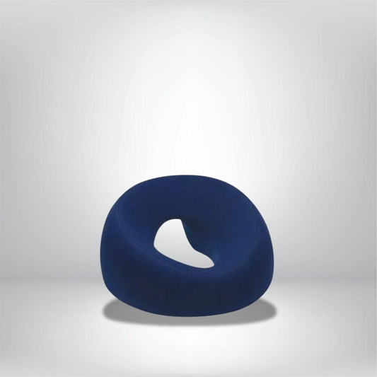 Coussin décoratif en forme de donut, en tissu bleu, posé sur un fond neutre