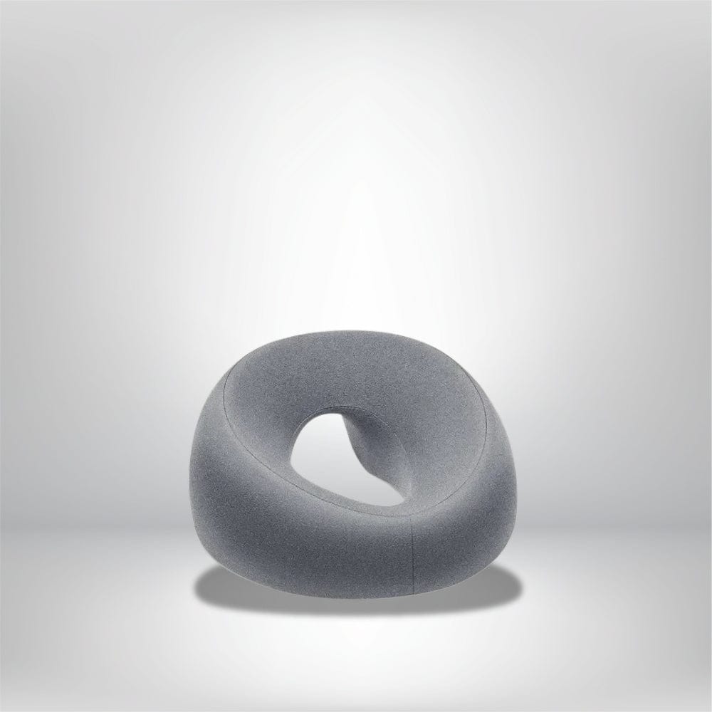 Coussin décoratif en tissu gris, en forme arrondie avec une ouverture centrale, idéal pour un salon moderne