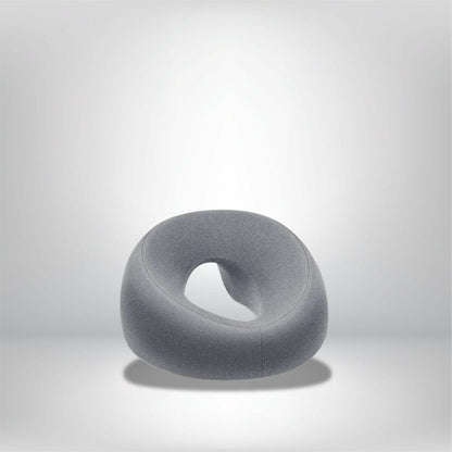 Coussin décoratif en tissu gris, en forme arrondie avec une ouverture centrale, idéal pour un salon moderne