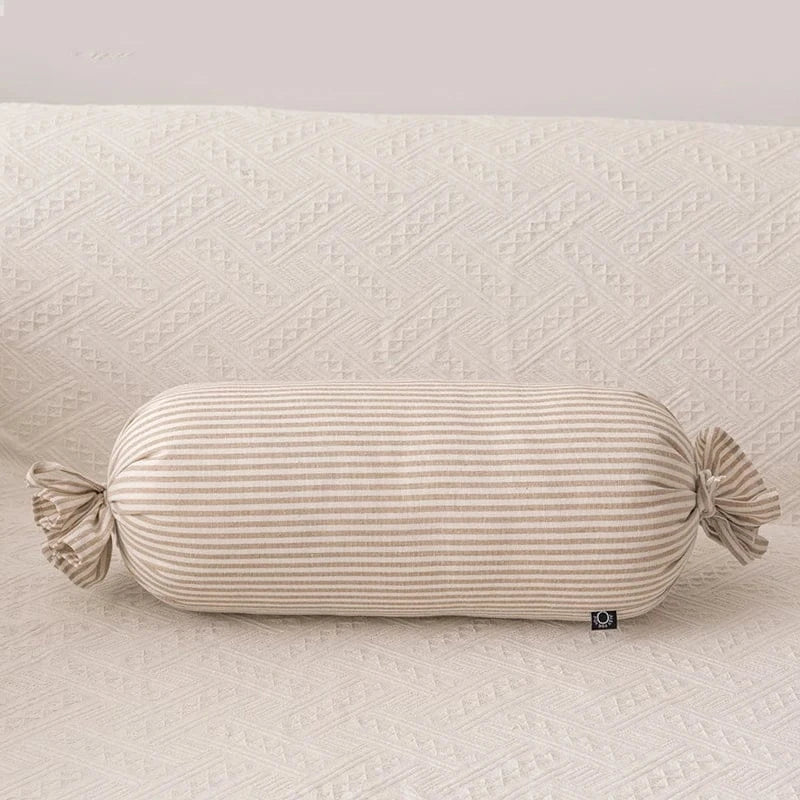 Coussin déco rayé beige sur un canapé aux motifs texturés, ajoutant une touche élégante à votre intérieur