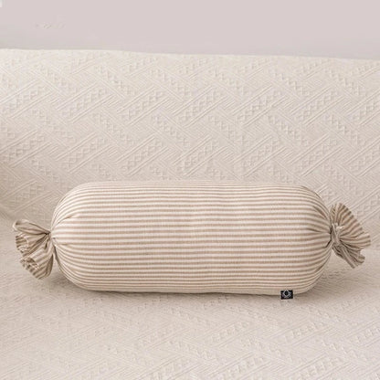 Coussin déco rayé beige sur un canapé aux motifs texturés, ajoutant une touche élégante à votre intérieur