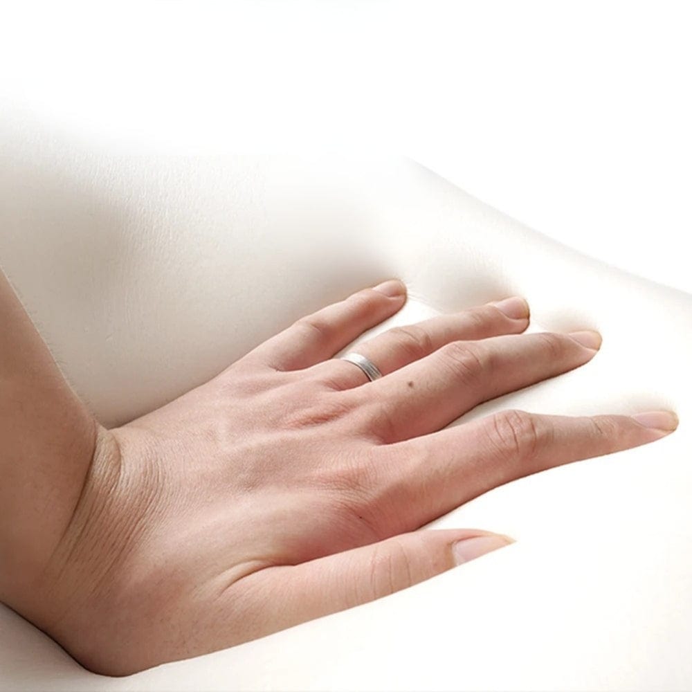 Main posée sur un coussin rehausseur blanc, offrant confort et soutien, idéal pour une voiture ou un siège