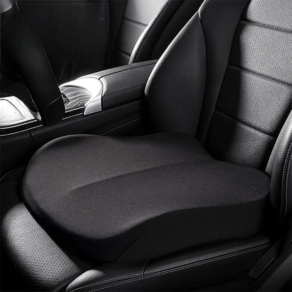Coussin rehausseur noir en forme ergonomique posé sur un siège en cuir de voiture