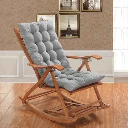 Coussin déco gris en velours sur un rocking chair en bois dans un salon élégant avec des murs décorés