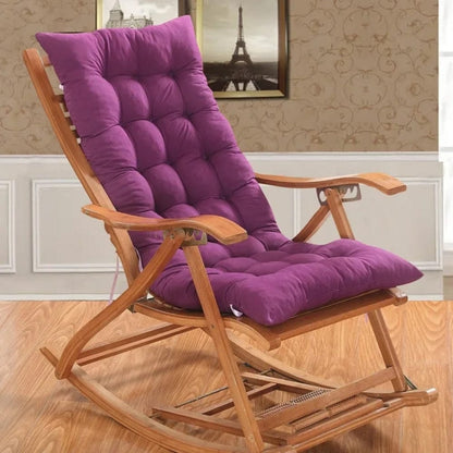 Coussin de rocking chair en velours violet, avec un design matelassé, reposant sur une chaise en bois clair