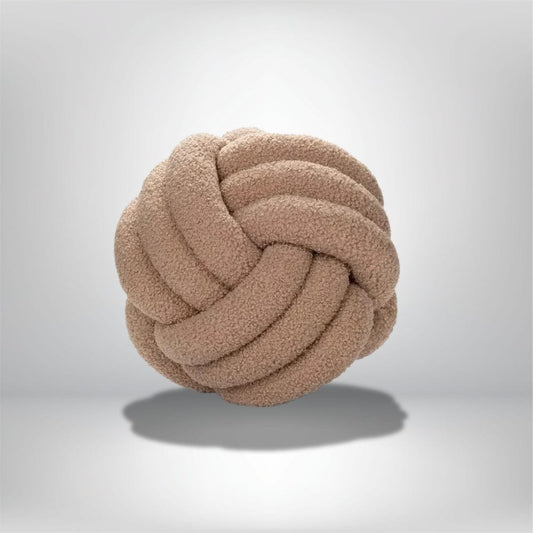 Coussin déco rond en tissu beige, avec un motif tressé, posé sur un fond neutre