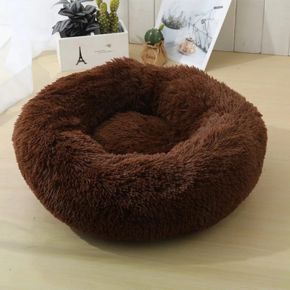 Coussin rond en fausse fourrure marron, posé sur une table en bois, idéal pour le confort des animaux
