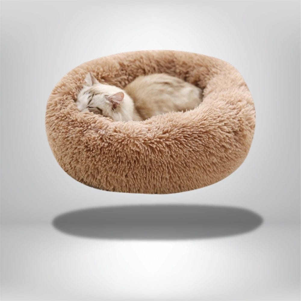 Coussin rond en fausse fourrure beige, idéal pour un chat, posé sur un fond neutre