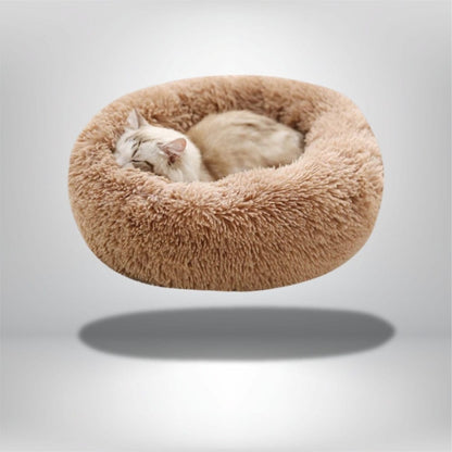 Coussin rond en fausse fourrure beige, idéal pour un chat, posé sur un fond neutre